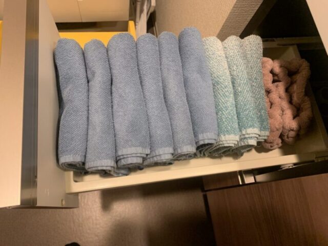 洗面台の引き出しにフェイスタオルとヘアバンドを収納しています。手前には身体を拭くタオル、奥には洗面台に掛けておくタオルを収納しています。タオルの色で用途を分けています。